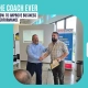 how to improve business performance: A business coach smiling and shaking hands with a client who holds a certificate in a bright workshop room