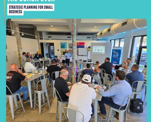 Strategic planning for small business: A business coach leading an interactive workshop while small-business owners sit around tables, reviewing strategy worksheets and taking notes in a bright, collaborative studio