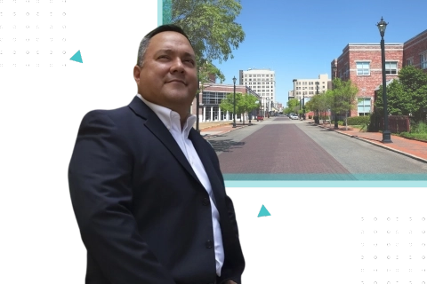 Professional business coach in Alexandria LA standing confidently in a suit with a downtown city view in the background